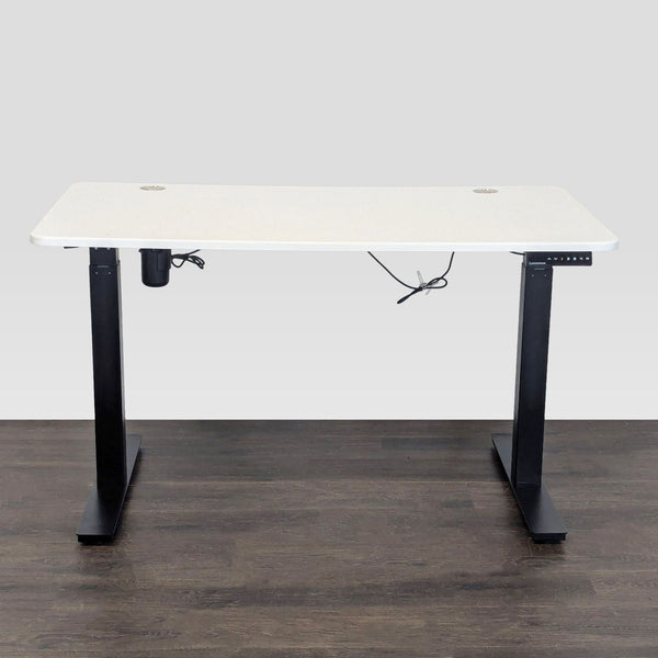 White standing desk with black frame, electric height adjustment, and cable ports by Autonomous, category Desks.  