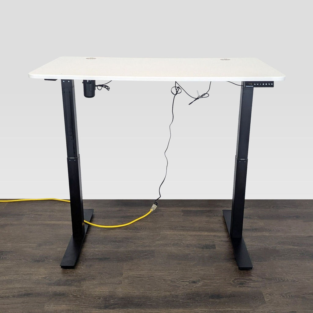 Modern Autonomous desk with sleek white top, black legs, cable management, and sit-stand electric controls.  