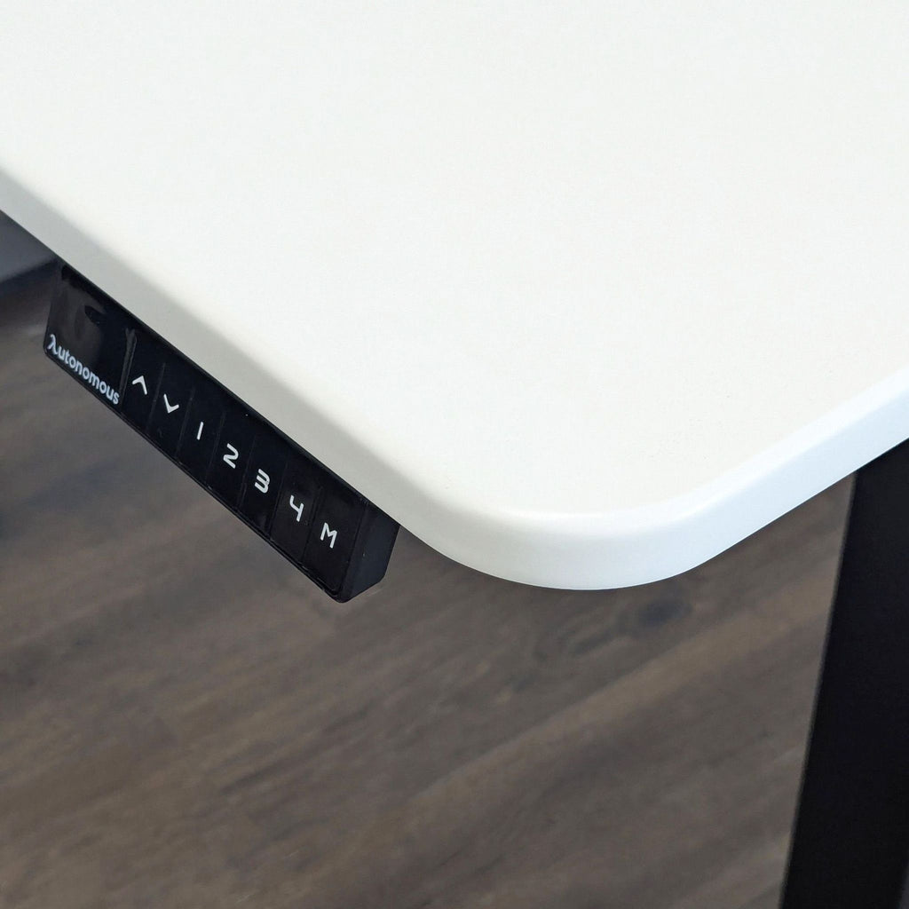 Ergonomic Autonomous desk, white surface and black base, electric lift, for flexible and organized workspaces.