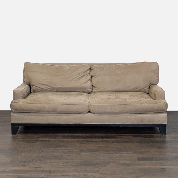 Pottery Barn beige 3-seat sofa with removable cushions and dark wood legs, shown in a living space.