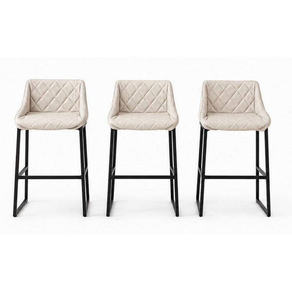 Three beige quilted leather stools with black steel bases by Studio Piet Boon, shown from the front.