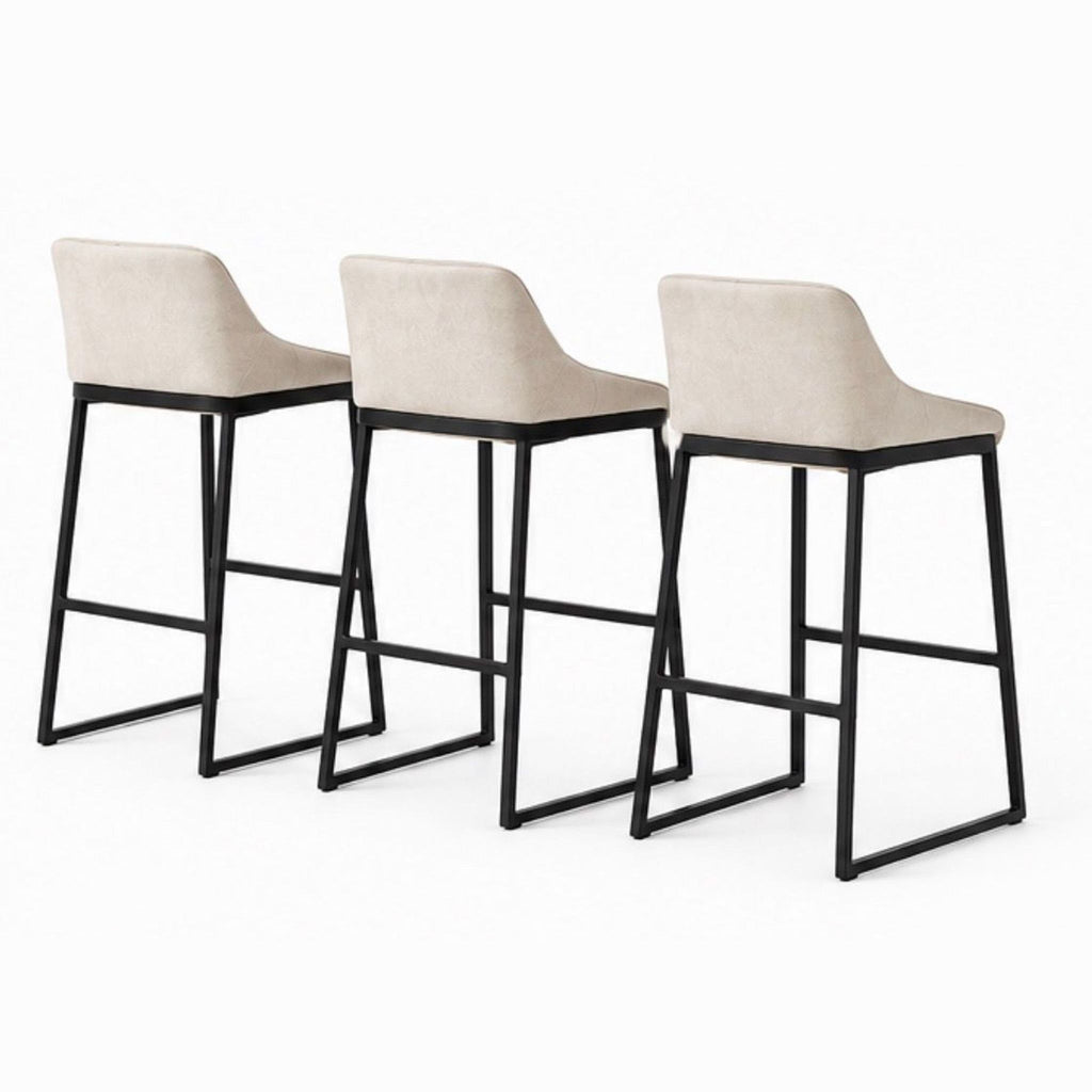 Back view of three Studio Piet Boon stools showcasing smooth beige leather upholstery and sturdy black steel legs.