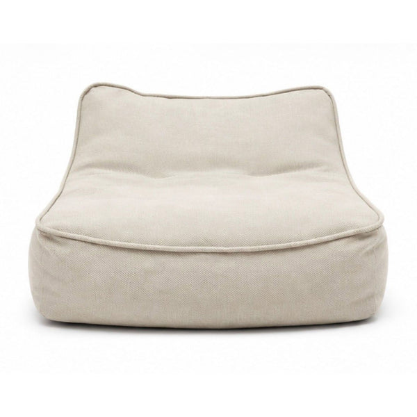 A modern Paola Lenti chair with soft beige fabric and a wide, plush seat for comfortable lounging.  