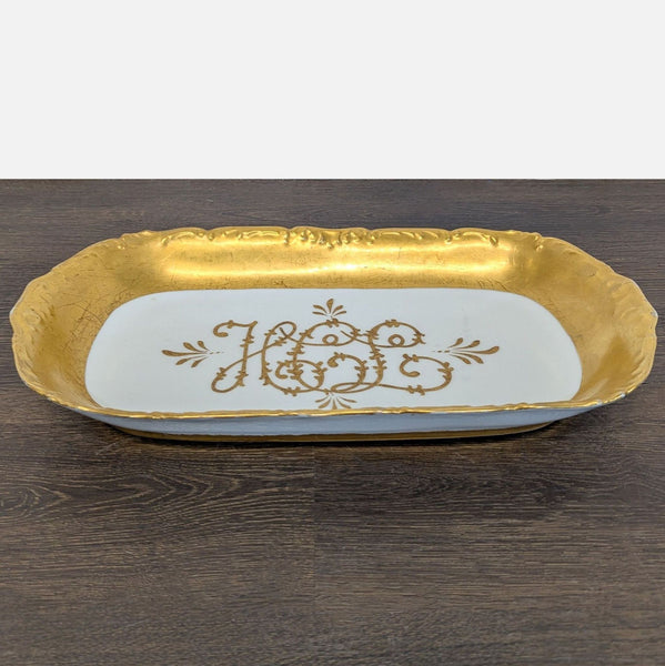 Porcelain serving tray with gold trim and elegant script in the center, ideal for snacks or decor.
