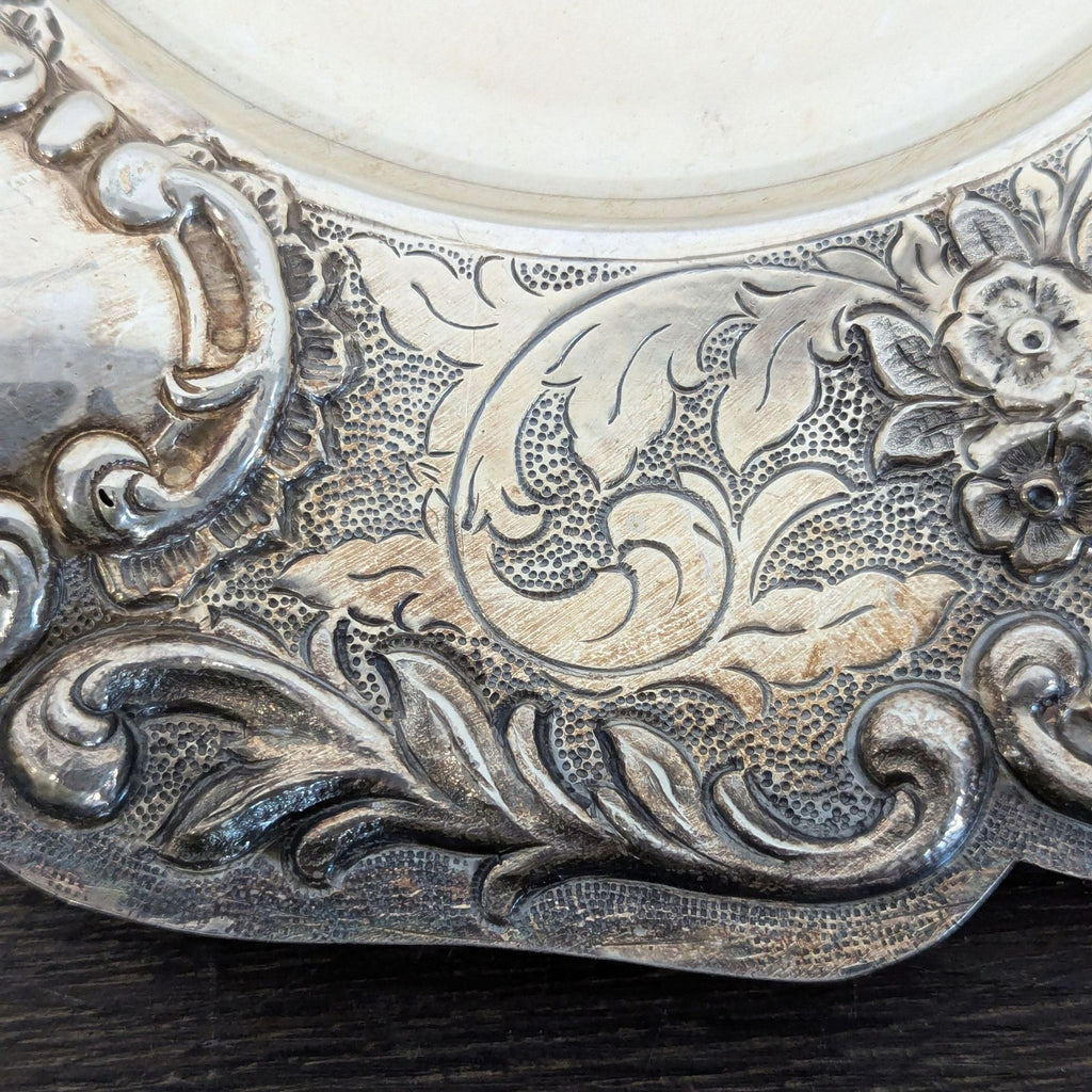 Antique decorative silver plate showcasing detailed Repoussé floral patterns and aged finish, ideal for collectors.