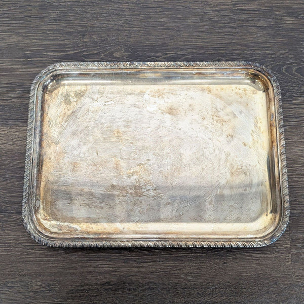 Rectangular silver-plated serving tray with decorative edge and vintage tarnish, suitable for drinks or snacks.