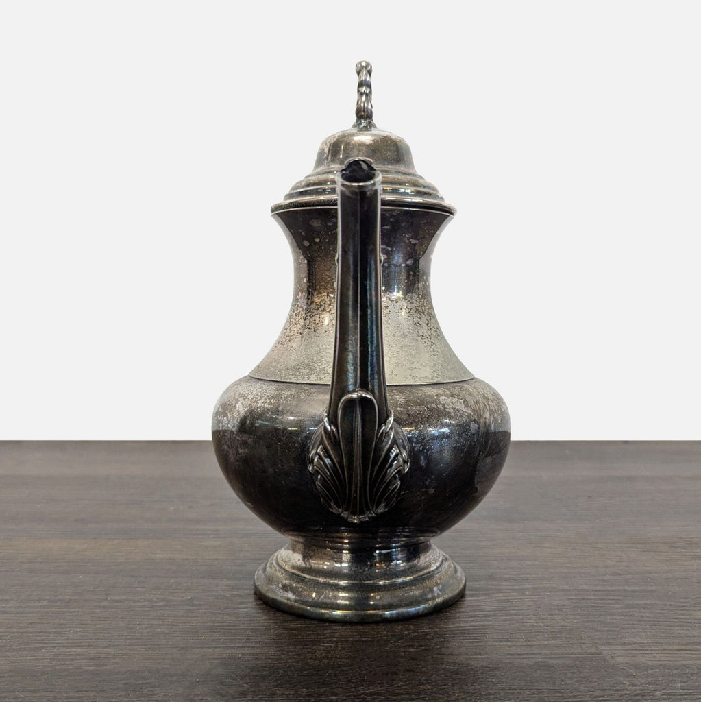 Elegant vintage teapot with a decorative handle, detailed spout, and visible patina, perfect for display.
