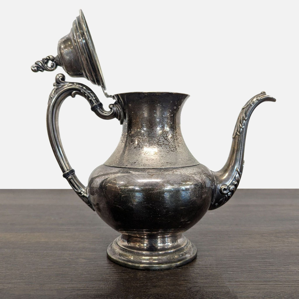 Classic silver-plated teapot featuring detailed craftsmanship, sturdy design, and natural aged finish.  