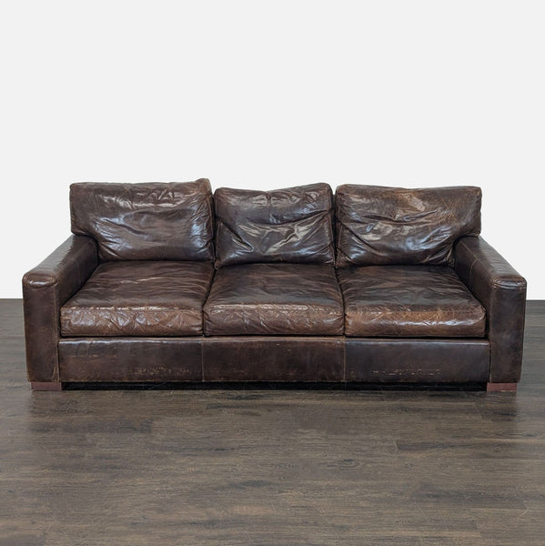 Restoration Hardware 3-seat sofa with brown worn leather, wide armrests, and a vintage, spacious design.