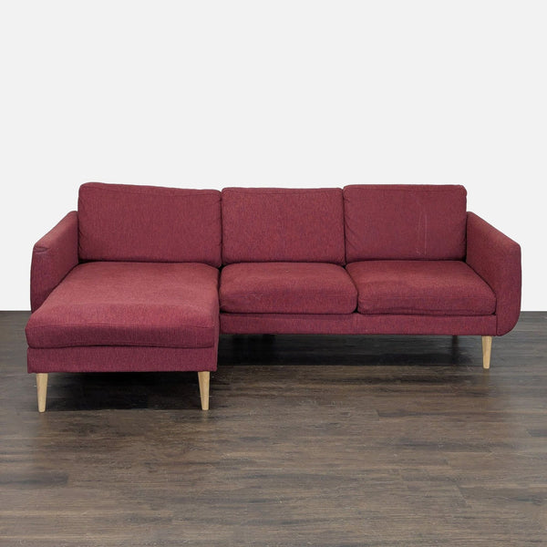 Deep red Ikea sectional with left-facing chaise and light wooden legs, seats three comfortably for modern living rooms.  