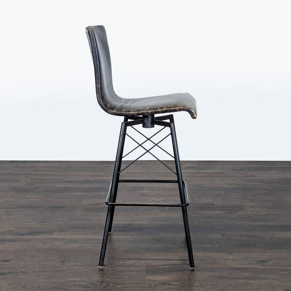 Four Hands ottoman with a sleek metal base and plush leather seat, perfect for contemporary interiors.