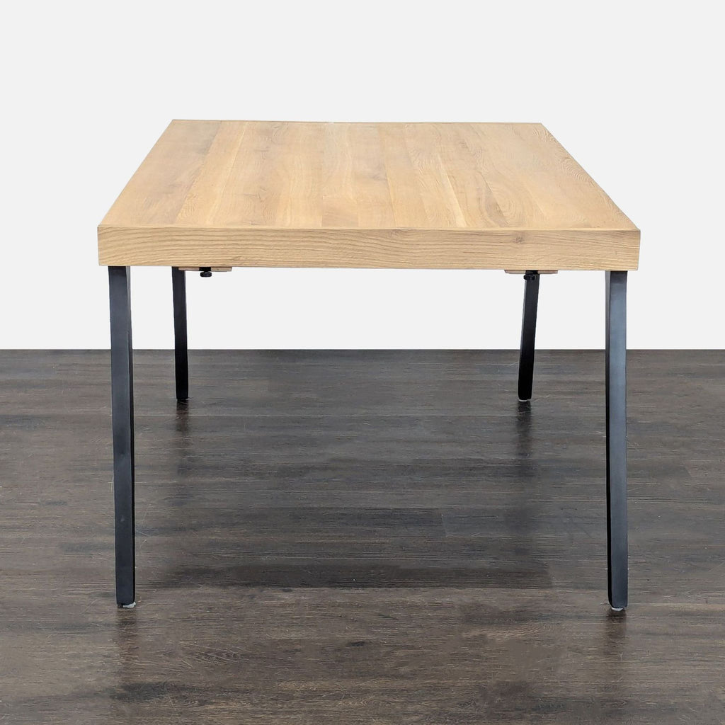 Modern white oak table from Crate & Barrel with two extension leaves and sturdy iron legs, seats eight.
