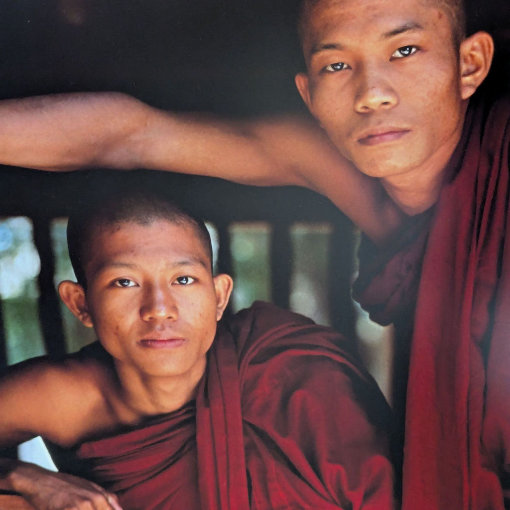 Peaceful scene of two monks at a window, captured in a colorful, detailed framed photographic print.
