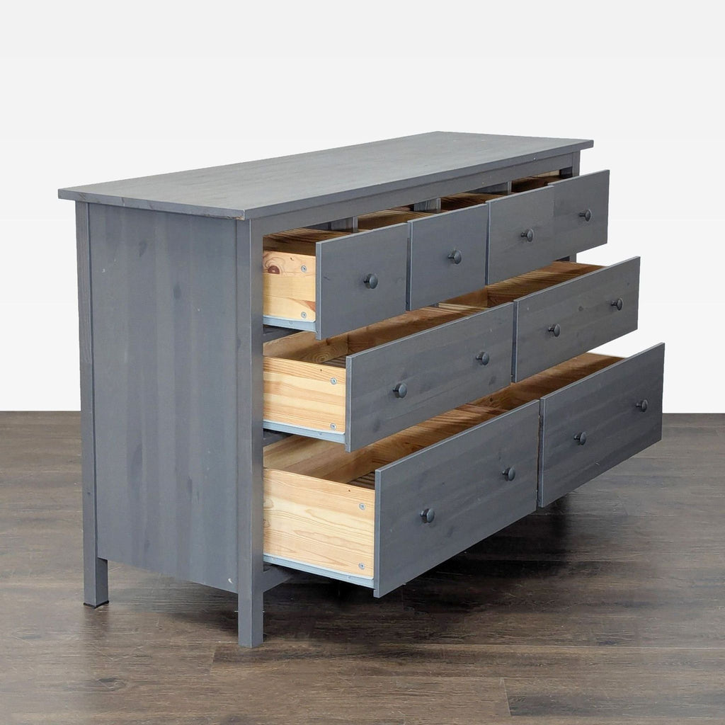 Sleek Ikea dresser in gray, featuring eight roomy drawers for clothes or linens; fits any contemporary space.