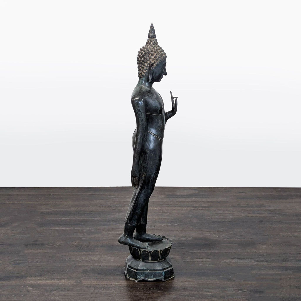 Sculpture of Buddha in bronze, featuring a peaceful pose, detailed hair and robe, ideal for tranquil decor.