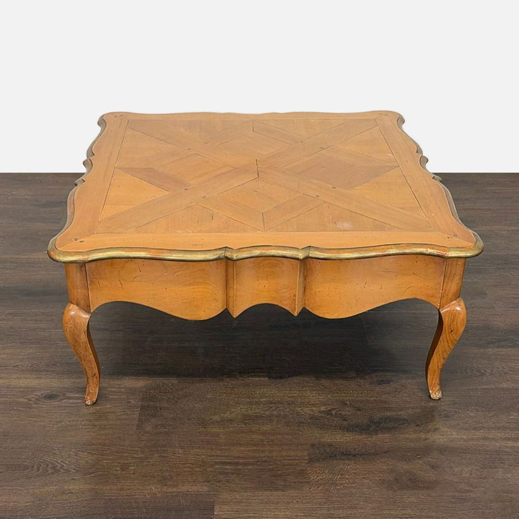 Parquet-top wooden coffee table with curved legs and hidden storage drawer.