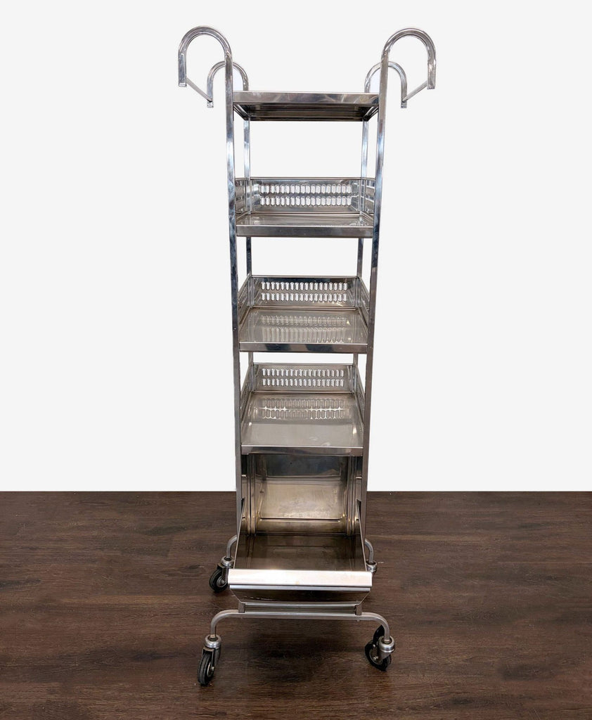 Stainless steel utility cart with four shelves and wheels, ideal for organizing kitchen supplies.