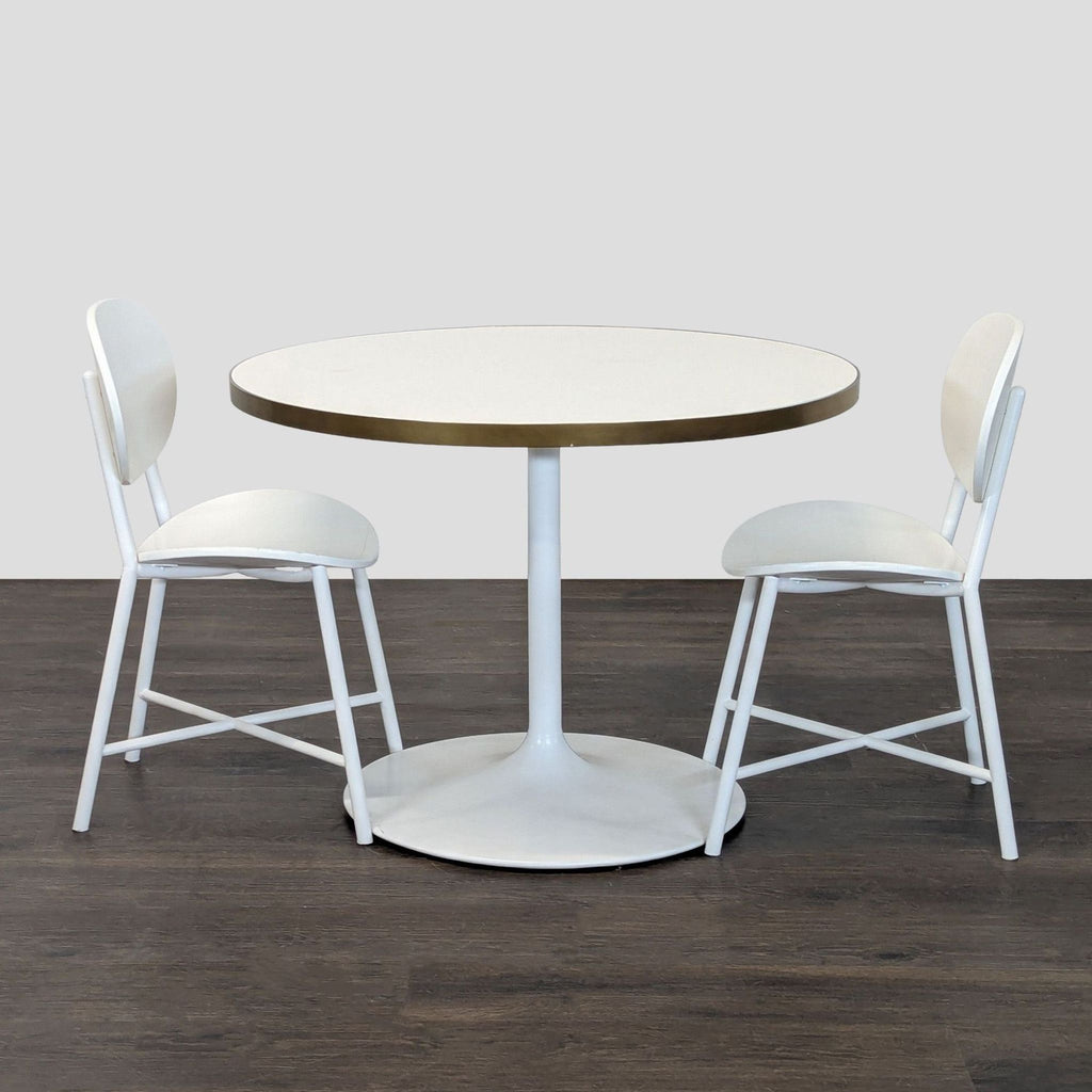 RH Baby & Child dining set with round white table, gold trim, and two matching white chairs.