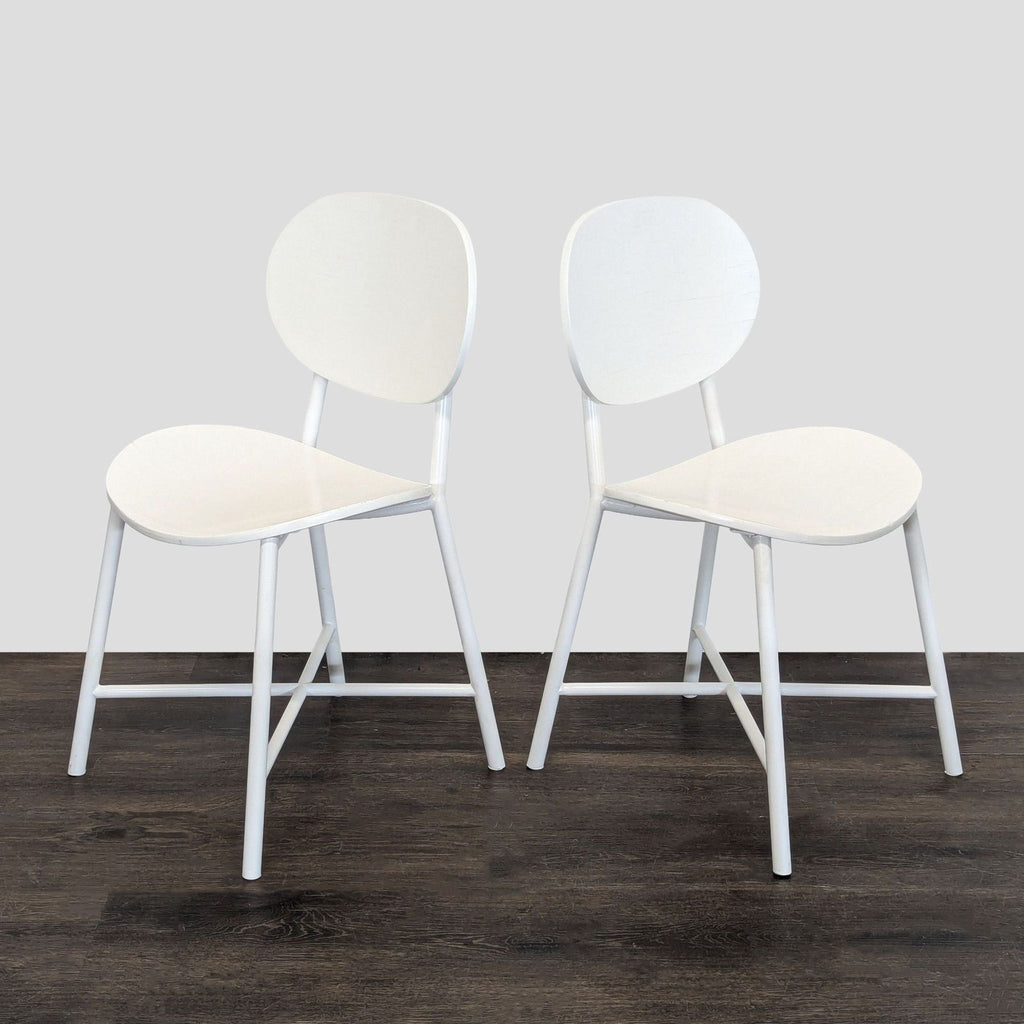 Compact round dining table and two white chairs with gold-tone detailing, ideal for children's dining spaces.