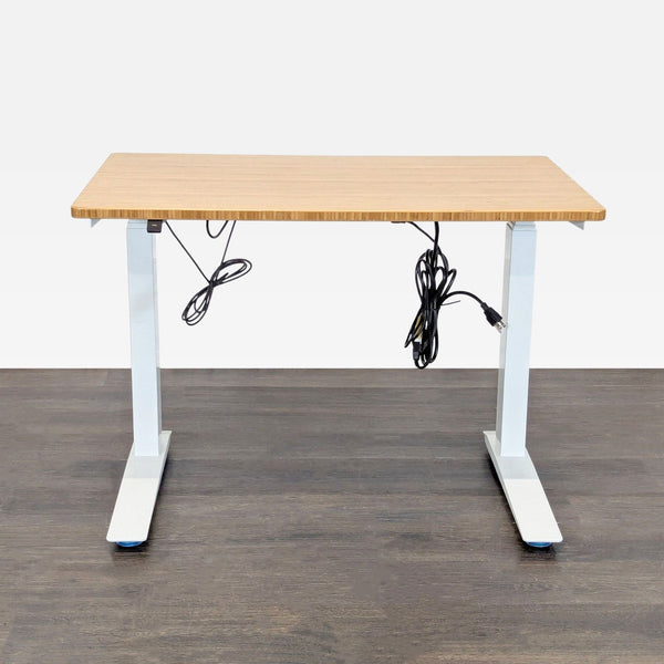 Fully adjustable-height desk with bamboo top and white frame, ideal for sit-stand work setups, includes cables.