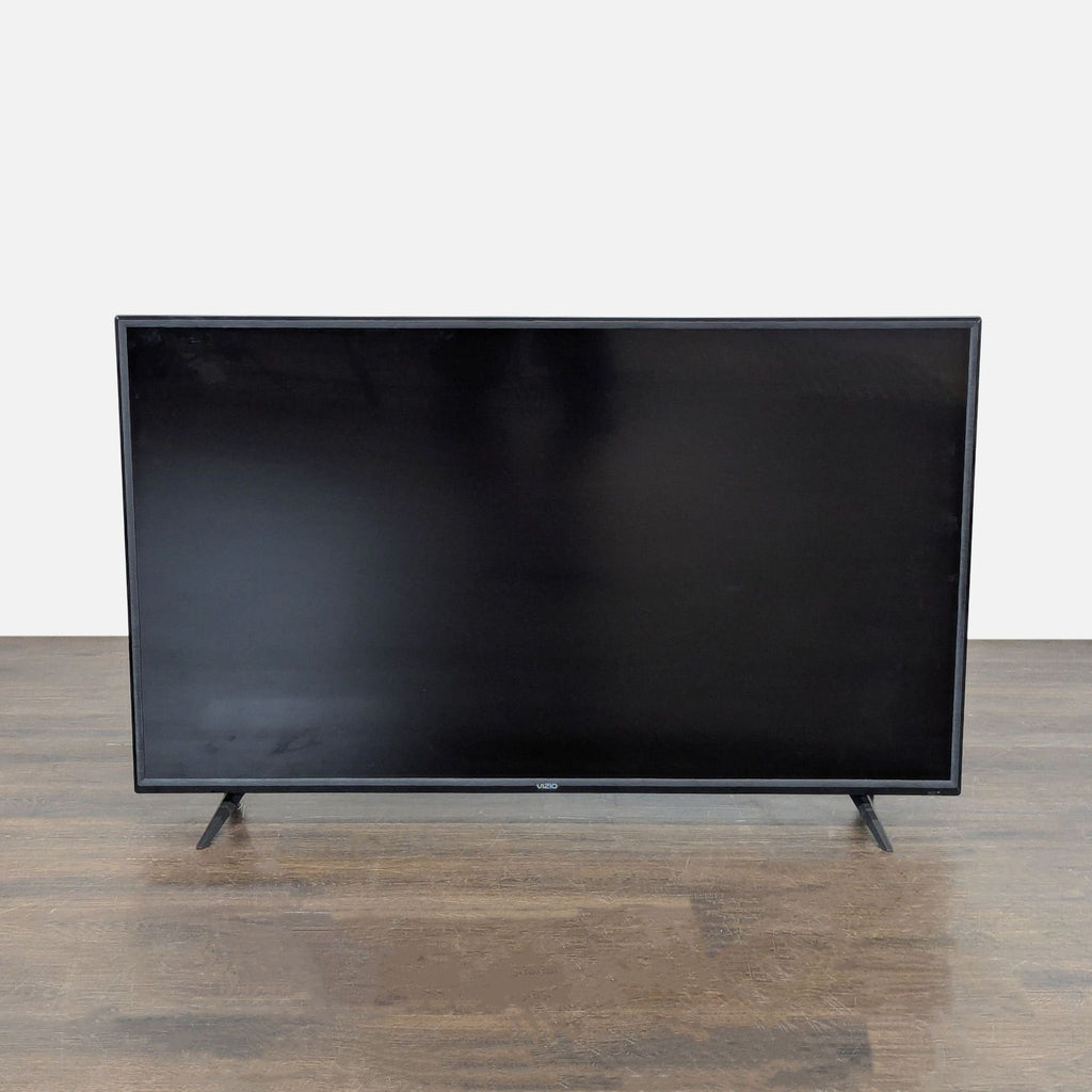 Vizio 55-inch LED TV with slim profile and sturdy legs, ideal for home entertainment setup.  