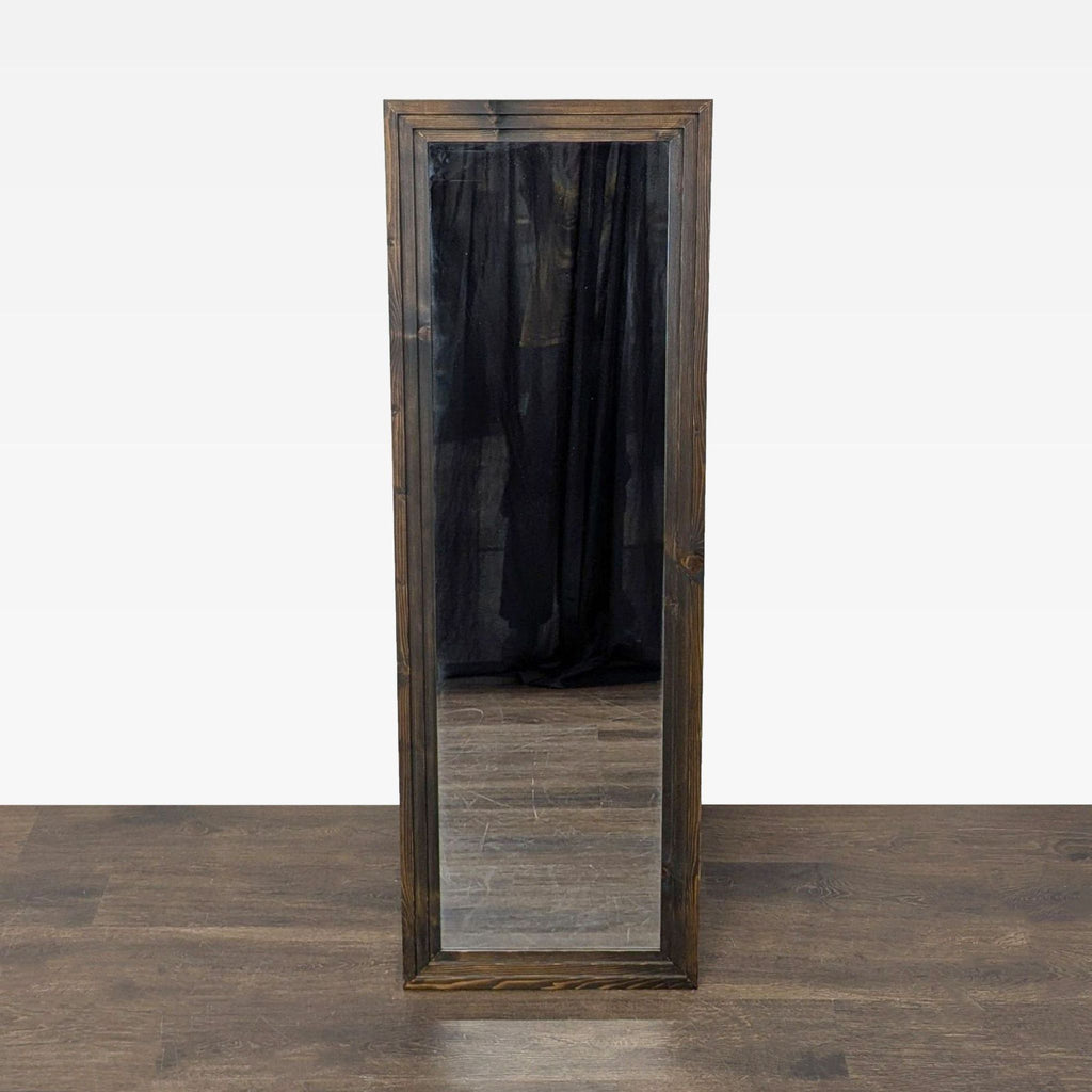 1. Full-length rectangular mirror with a dark wooden frame, standing on a wood floor against a plain backdrop.