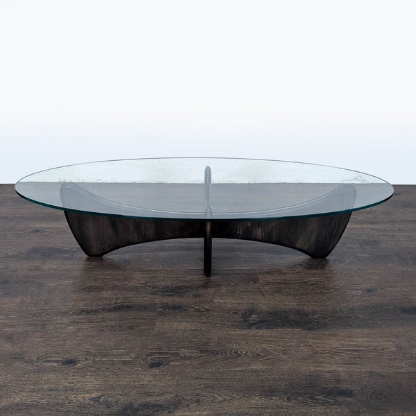 Mid-century inspired coffee table with sculpted solid wood base and rounded edges, topped with tempered glass.
