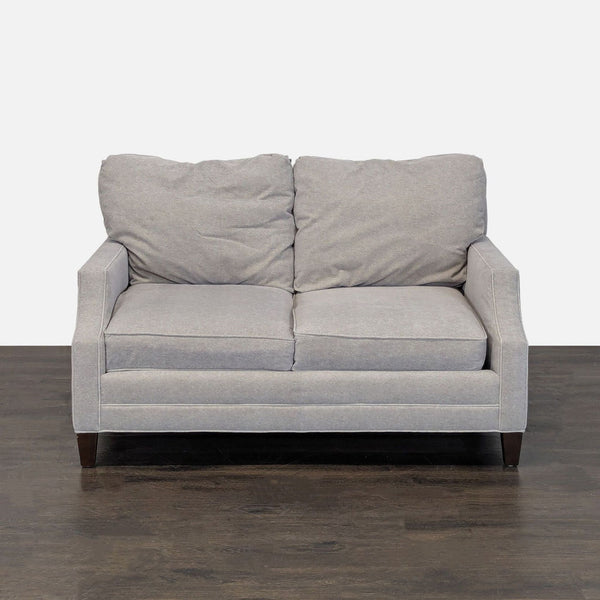 Lexington loveseat with light gray fabric, cushioned seats, and wooden legs, ideal for modern small spaces.  