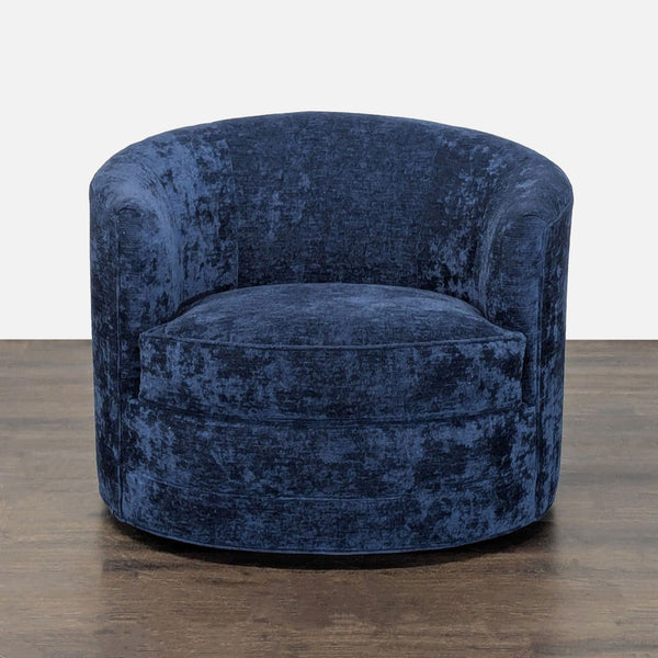 Modern blue velvet Kava lounge chair with a rounded shape and swivel base, perfect for stylish living rooms.