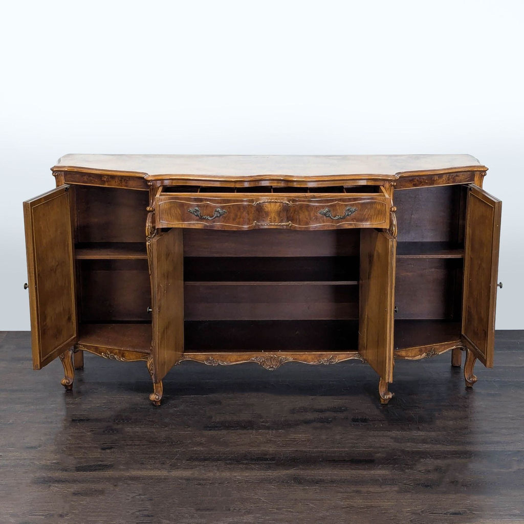 Carved four-door credenza with one drawer, serpentine front, and decorative burl inlay details.  