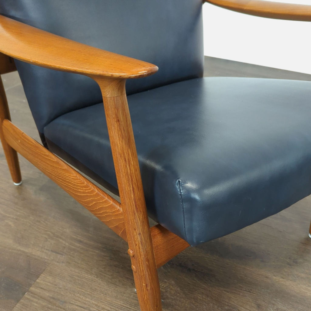 Comfortable leather-upholstered John Boné chair with high backrest and ottoman, perfect for relaxing in any lounge.