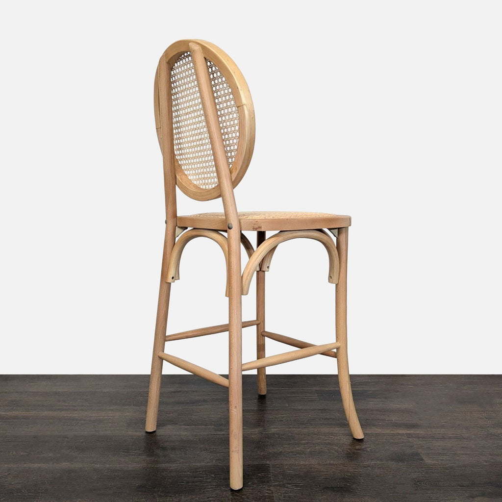 Woven rattan seat and cane backrest on a bentwood stool frame, designed with a practical footrest.