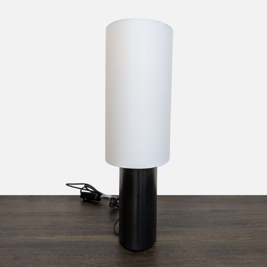 Contemporary lamp featuring a sturdy black oak base and clean white shade, perfect for soft room lighting.