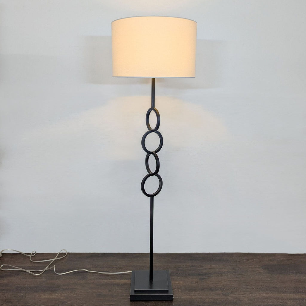 Modern Black Floor Lamp with White Drum Shade and Linked Ring Design