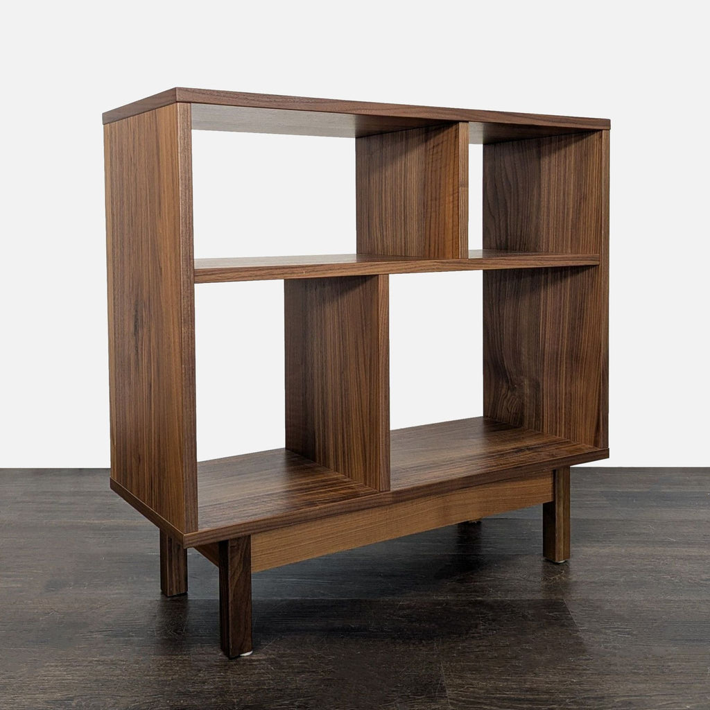 Compact Room & Board bookshelf in warm wood finish, featuring multiple shelf sizes for organized storage.  