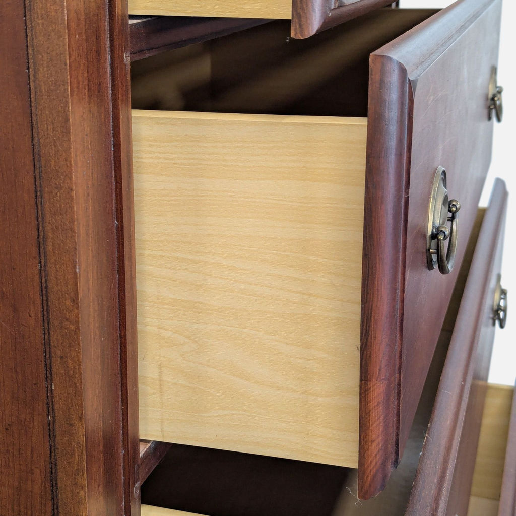 Sturdy Broyhill drawer chest in warm wood tone, offering ample storage with brass-accented handles.