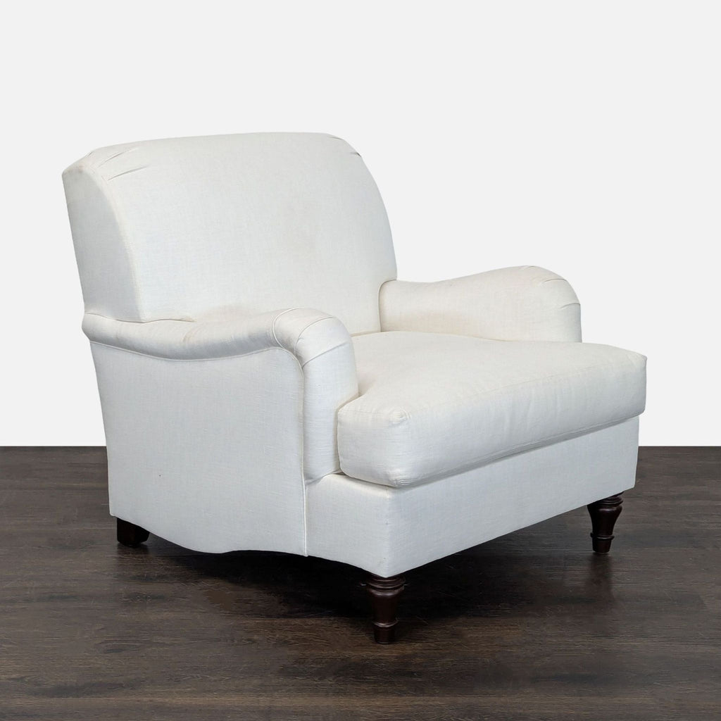 Elegant Pottery Barn upholstered lounge chair in soft white, featuring sturdy wooden legs and plush comfort.