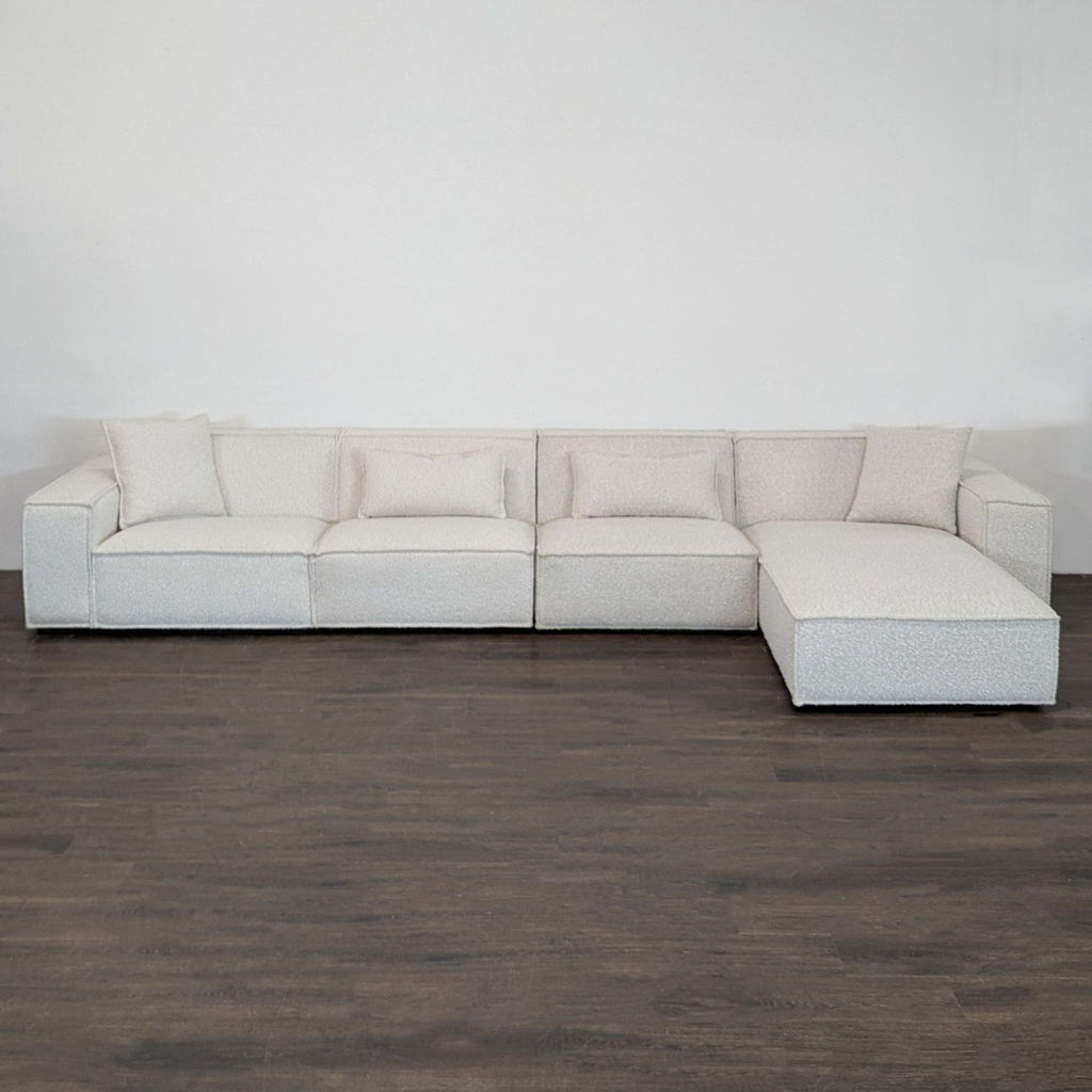 Modern Rove Concepts sectional with right-facing chaise, boucle fabric, wide arms, and accent pillows.