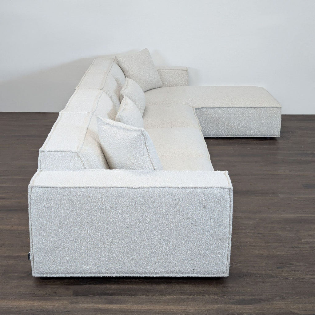 Boucle-upholstered sectional sofa by Rove Concepts featuring deep seats, wide arms, and matching pillows.