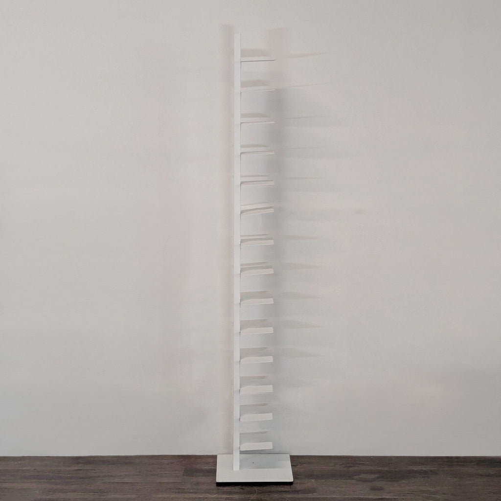 Vertical white bookshelf by Bruno Rainaldi, offering stylish storage for books or magazines.  