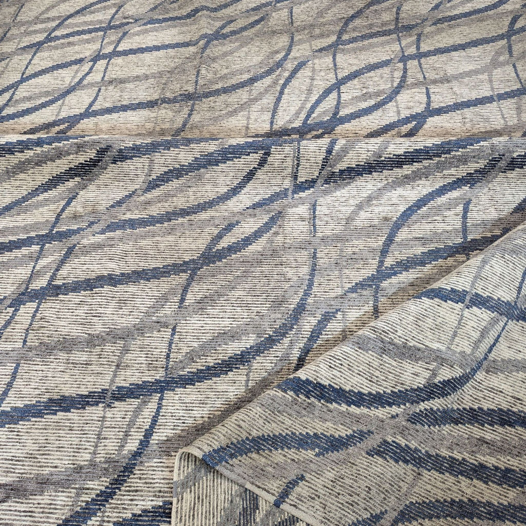 Modern abstract Kalaty rug with blue accents and neutral tones, made of soft, durable wool for versatile decor.