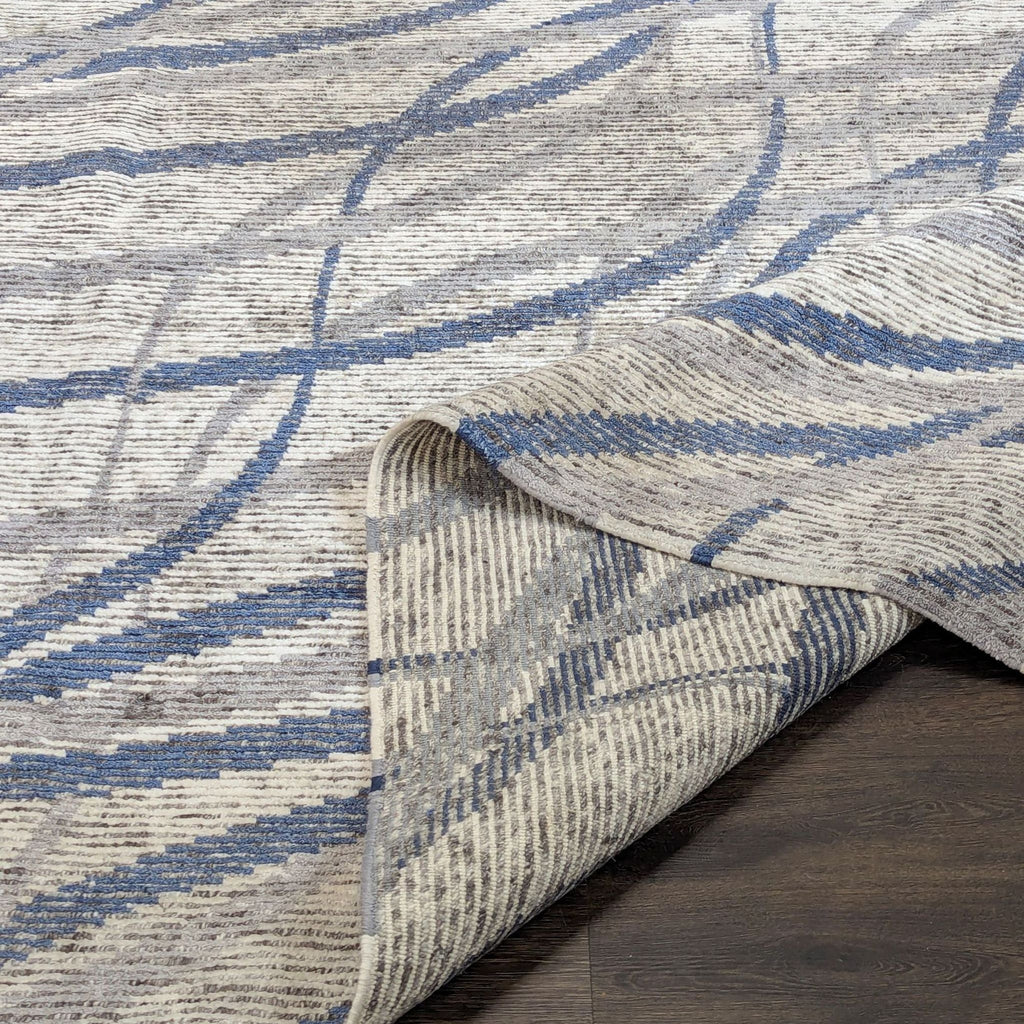Soft wool Kalaty rug with stylish abstract design, blue highlights, and easy-care low pile for living spaces.