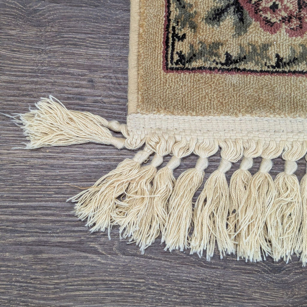 Elegant rug featuring intricate flowers and leafy borders in muted tones, complete with matching fringed edges.