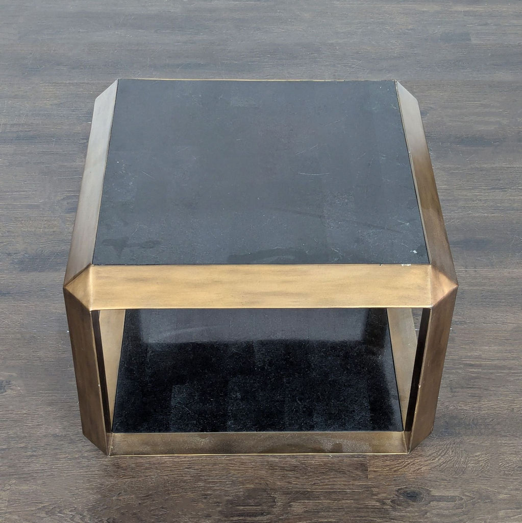 Modern coffee table with stone tabletop, shelf, and slim brass frame.