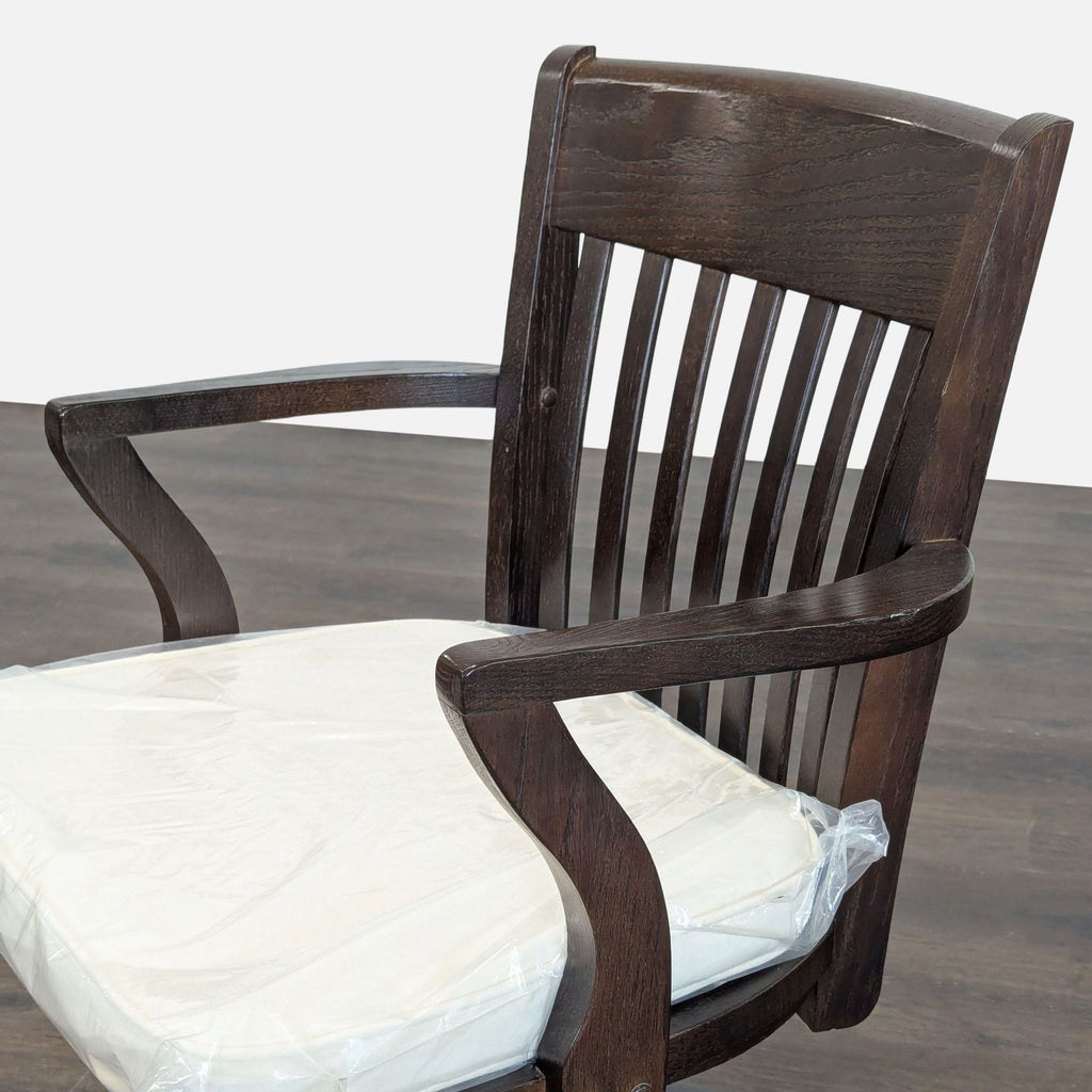 3. Close-up of Pottery Barn chair showing rich wood grain, slatted back, and white cushioned seat.