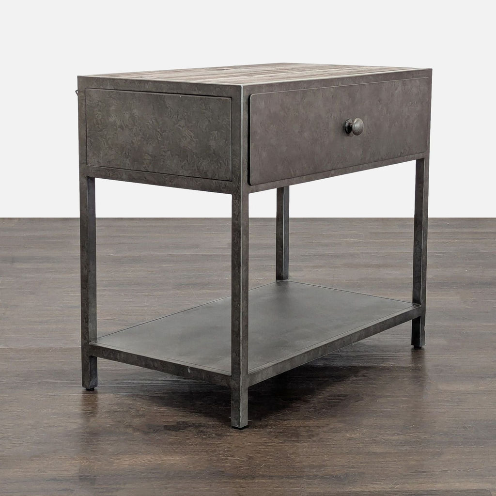 2. Side-angle view of a Pottery Barn end table featuring a metal frame, drawer, and open lower shelf.
