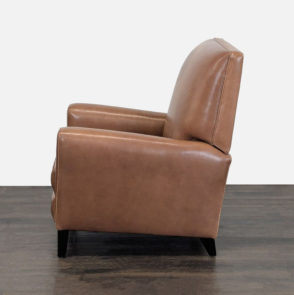 1. Side view of a Room & Board lounge chair in cognac leather, showing clean lines and cushioned backrest.