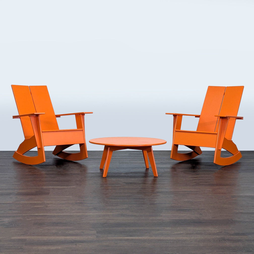 Two modern orange rocking chairs with a matching round table from Room & Board, perfect for outdoor spaces.