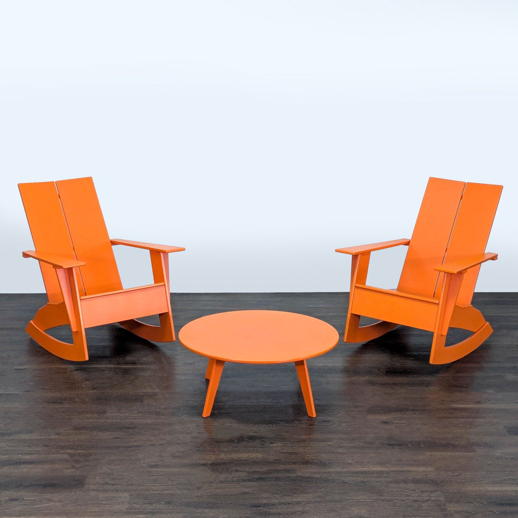 Room & Board outdoor set featuring two bright orange rocking chairs and a circular coffee table on a patio.