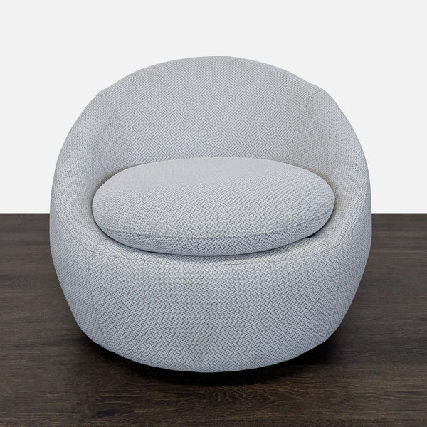 Modern lounge chair with light grey fabric and a rounded design, perfect for relaxing in any living space.
